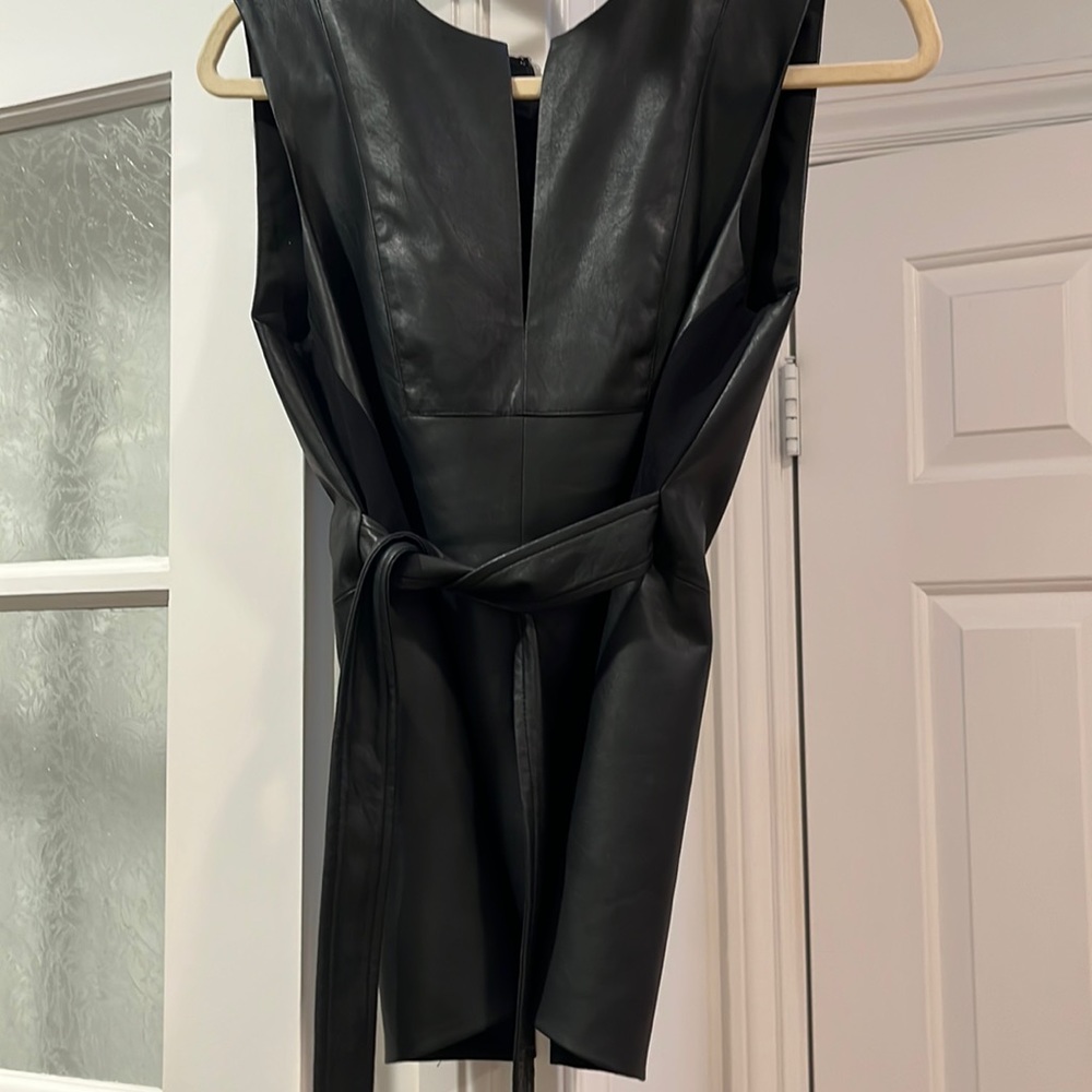 Black faux leather shell with cut out next and faux leather tie..zip back